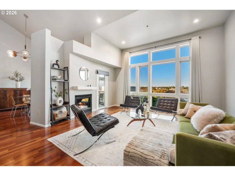 Penthouse condo living room partially staged around the client’s own green sofa, with new art, rugs and decor